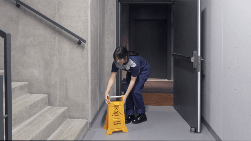 Woman putting up caution sign