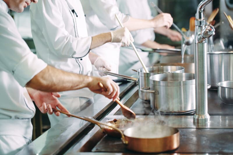 Chef cooking vegetables in wok pan