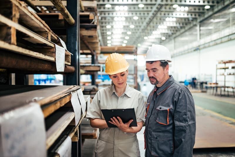 Inspector talking with factory worker.