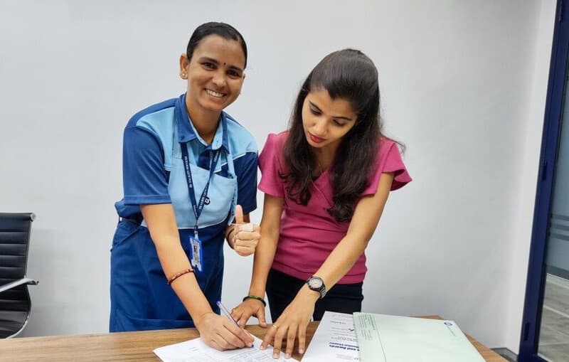 Two women signing papers crop