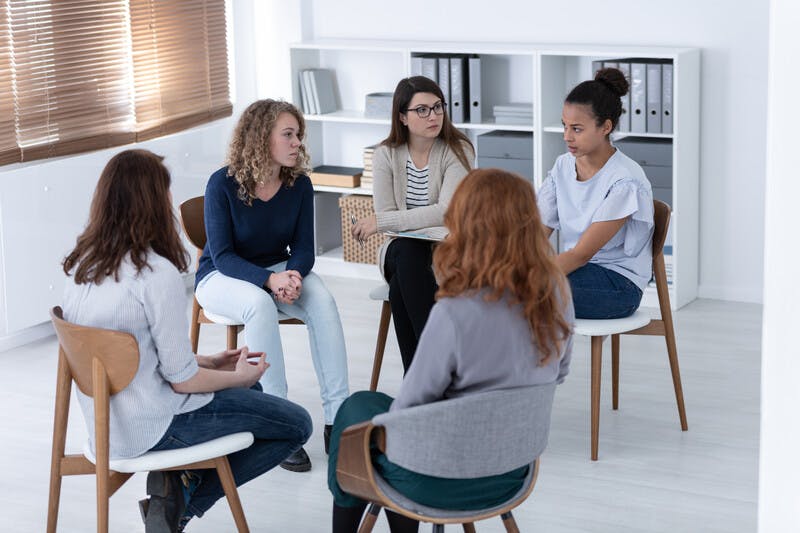 women supporting each other during psychotherapy group meeting