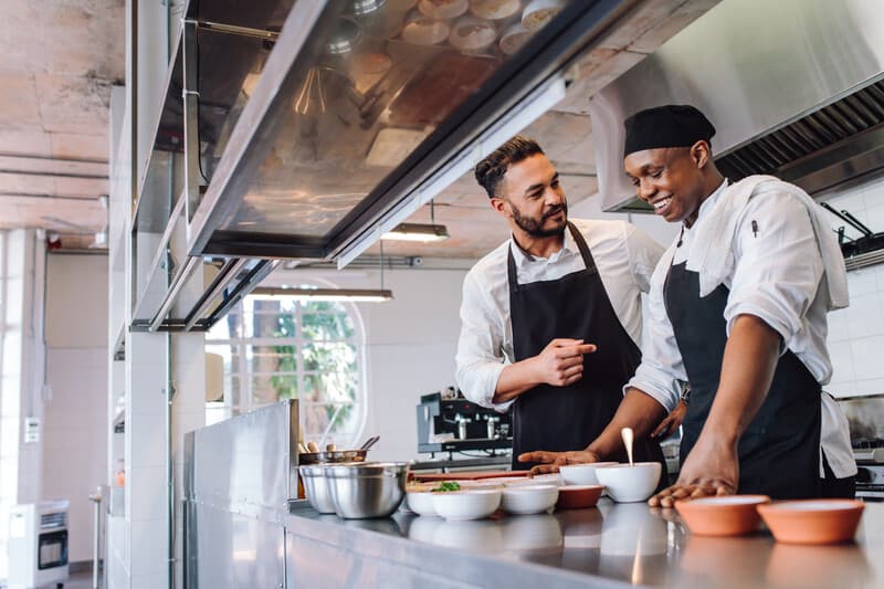 Chefs cooking food at cafe kitchen