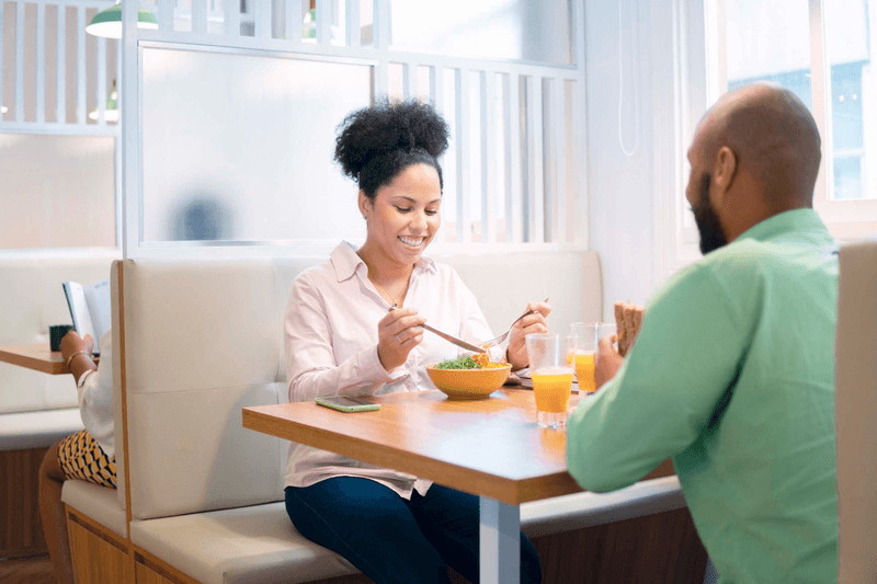 Brazilian female boss eating at office cafeteria. .