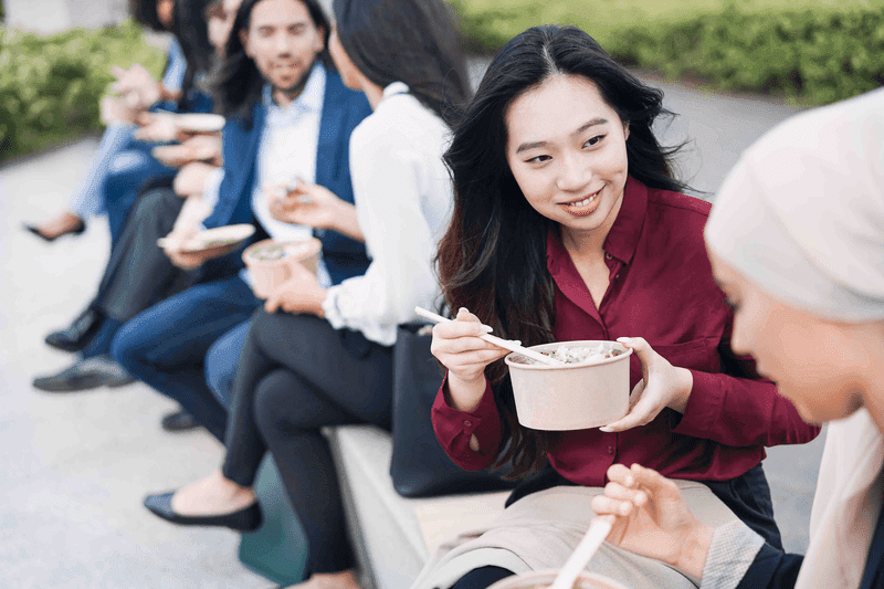 Multiethnic business people doing lunch break outdoor from office building - Focus on asian girl face