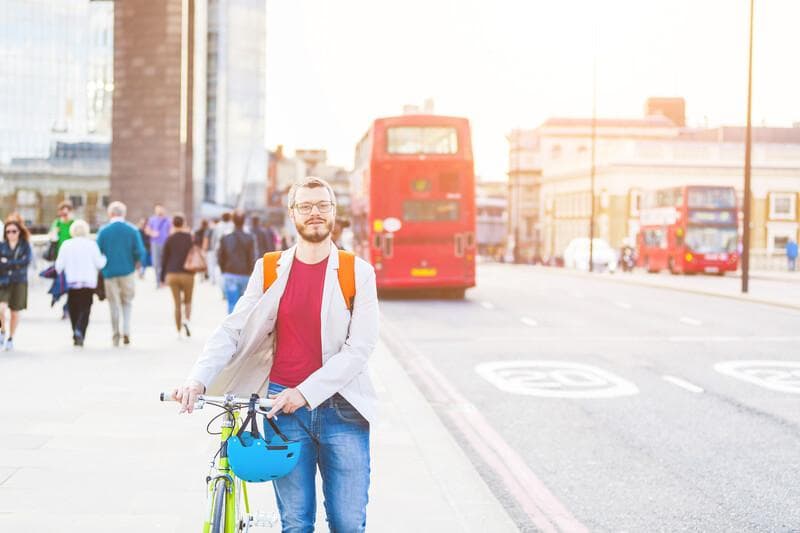 Hipster man walking on London bridge and holding his fixed gear bike