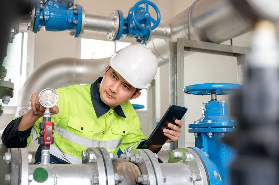 Web_Tablet-male industrial engineer Controlling the operation of water pipes and water systems in engineering plants. Utilities Water storage pipes a